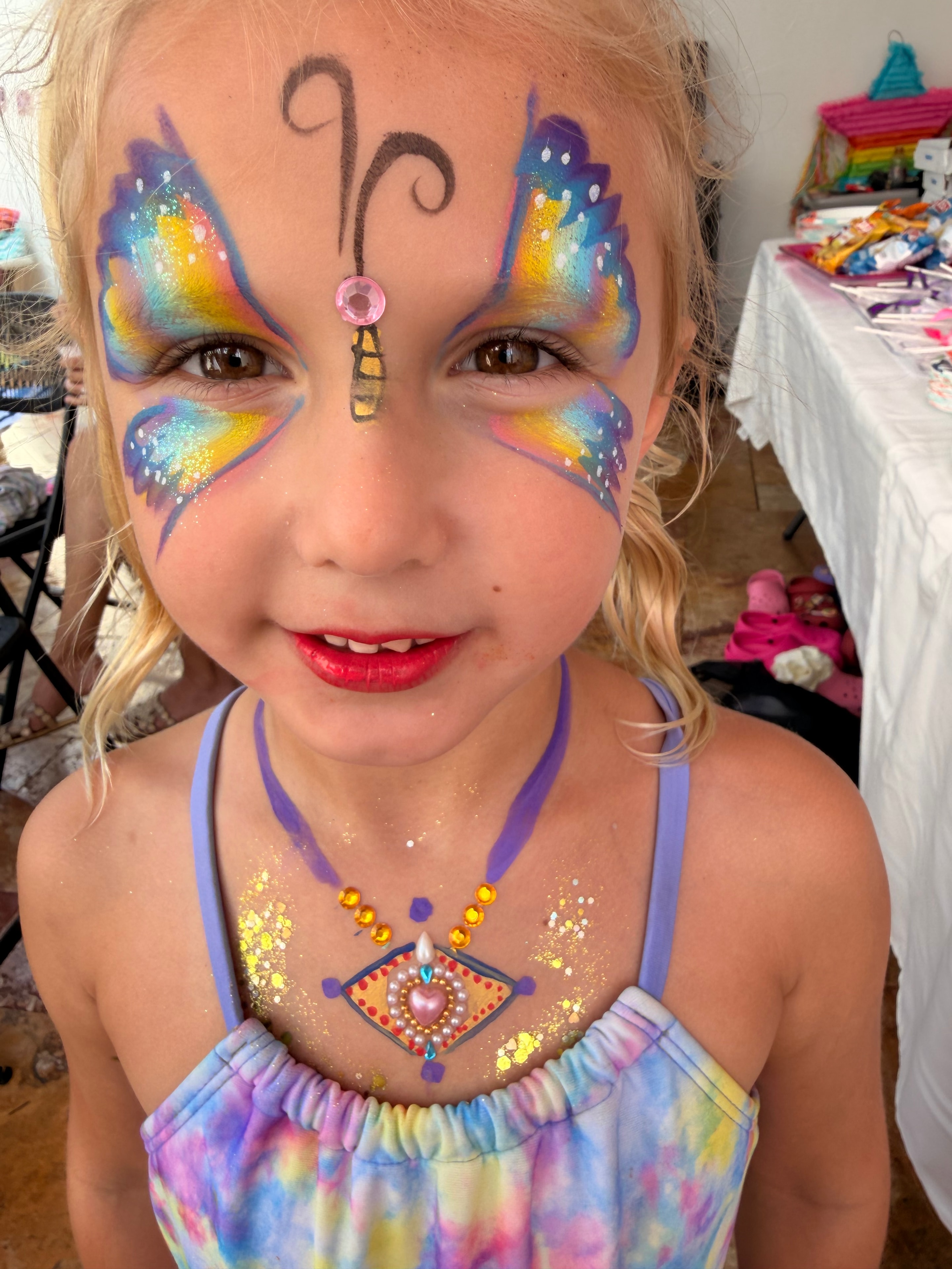 Rainbow butterfly with gems face painting by OOOPSY Face Painting Team
